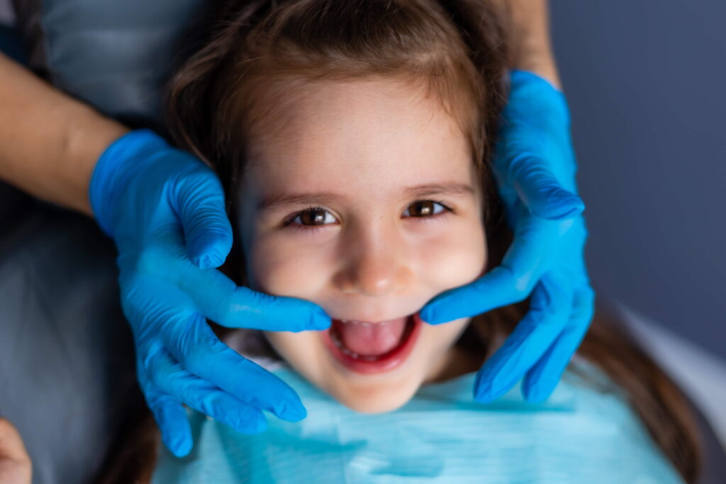 child getting her teeth checked by dentist